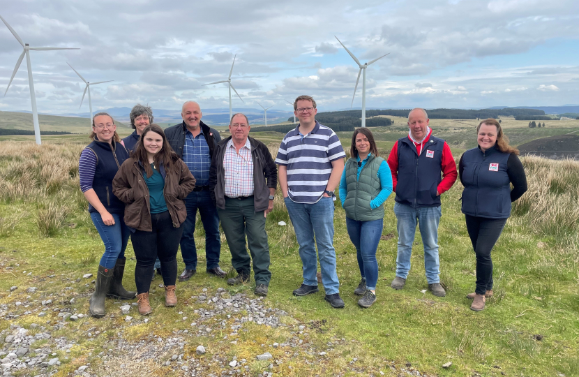 Joel James MS with FUW and Jones Family on hill farm with wind turbines in background