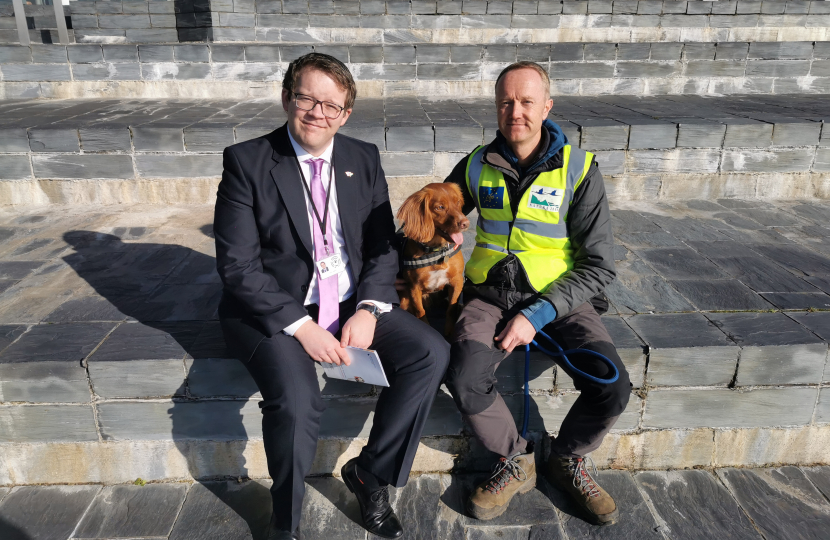 Joel James with Jinx the Biosecurity Dog on the steps of the Senedd