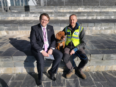 Joel James with Jinx the Biosecurity Dog on the steps of the Senedd